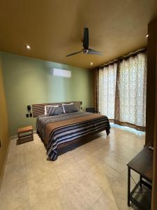 a bedroom with a large bed and a ceiling fan at Casa Colibrí in Zipolite
