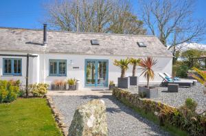 a white house with a garden in front of it at The Cowshed in Truro