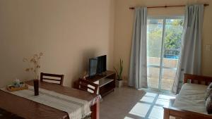 a living room with a table and a tv and a window at Rivera Este in Colón