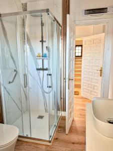 a glass shower in a bathroom with a toilet at Villa Hermida in Sanxenxo +25 photos