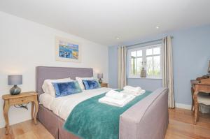 a bedroom with a bed with blue pillows at The Cowshed in Truro