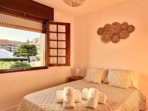 a bedroom with a large bed with a window at Villa Hermida in Sanxenxo