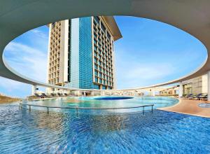 a large swimming pool in front of a tall building at Radisson Blu Chattogram Bay View in Chittagong
