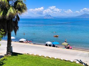 people on a beach with umbrellas in the water at patra's sea front apartment in Flámbouras