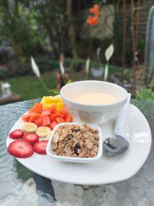 a plate of food with a bowl of cereal and fruit at Hostal Vistaguila in Salento