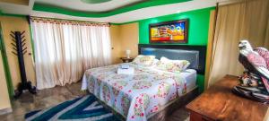 a bedroom with a bed and a green wall at Hostal Vistaguila in Salento