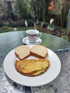a white plate with toast and a cup of coffee at Hostal Vistaguila in Salento