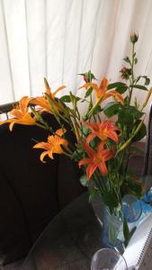 a vase filled with orange flowers on a table at RELAXViLLA MISKOLCTAPOLCA in Miskolc