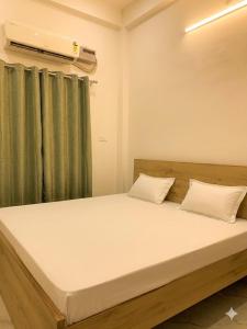 a bedroom with a large bed with a window at Baloon Rooms Taramandal in Gorakhpur