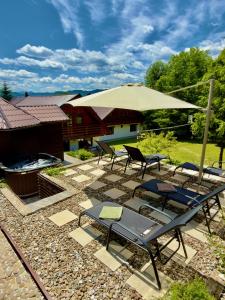 a patio with a table and chairs and an umbrella at Casa Rogin in Buhalniţa