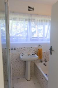 a bathroom with a sink and a bath tub at Seaward Studio Suite in Ramsgate