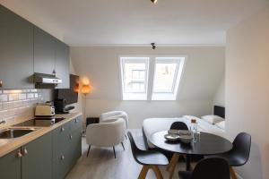 a small kitchen with a table in a room at Cozy apartment with a great location at "Residentie GAUGUIN" in Nieuwpoort +9 photos