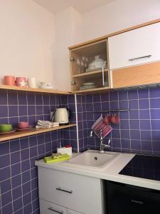 a kitchen with a sink and a blue tiled wall at Guest House Mijo Sokol in Brela +86 photos