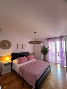 a bedroom with a large bed with pink pillows at Guest House Mijo Sokol in Brela