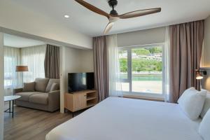 a bedroom with a bed and a tv and a couch at Silken Gran Hotel del Sella in Ribadesella +134 photos