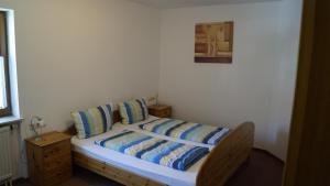 a bedroom with a bed with blue and yellow pillows at Weingut Bernhard in Daisendorf