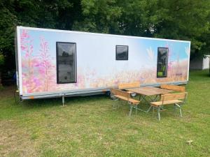 a large white trailer with a table and chairs at TinyHouse am Stadthafen in Hennigsdorf