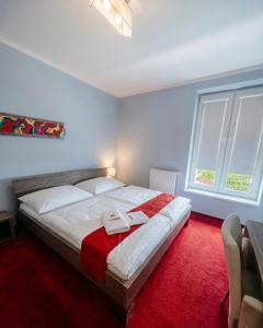 a bedroom with a large bed with a red carpet at Hotel Olympia in Kopřivnice