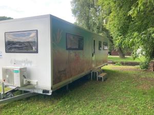 a trailer parked on the grass in a field at TinyHouse am Stadthafen in Hennigsdorf