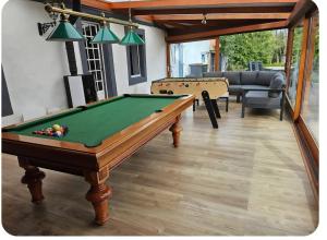 a living room with a pool table and a couch at La Cantraigne in Audembert