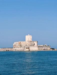 an old castle on an island in the water at Casa Luna in Paceco