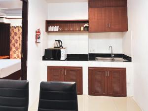 a kitchen with wooden cabinets and a sink at บ้านเกื้อ เดอะ ลิฟวิ่ง in Nakhon Ratchasima