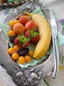 a plate of fruit on a table with a knife at Le Jardin d'Anna in Saint-Eutrope-de-Born
