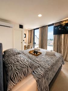 a zebra print bed in a room with a window at AAA Luxury Suites Split with Pool in Split +26 photos