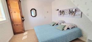 a bedroom with a blue bed with pillows on it at Bolumet in Neulliac