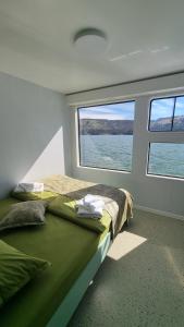 a bed in a room with a large window at Baraj Izvorul Muntelui Bibanu in Bicaz