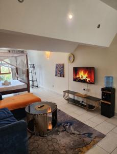 a living room with a couch and a fireplace at Beachfront Studio in Diani Beach