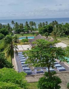 an aerial view of a resort with a pool and the ocean at Beachfront Studio in Diani Beach