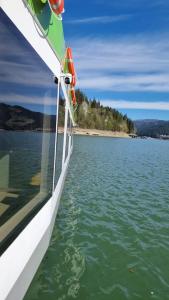 a boat on a body of water at Baraj Izvorul Muntelui Bibanu in Bicaz +5 photos
