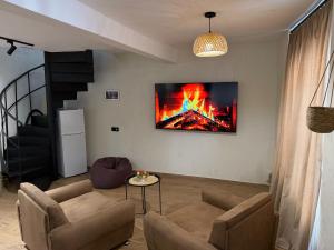 a living room with a fire painting on the wall at Duplex Hause in Telavi