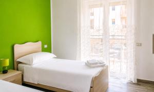 a bedroom with a white bed and a green wall at Paky' S House in Policoro