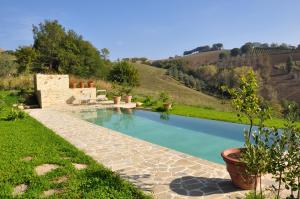 une piscine au milieu d'un champ herbeux dans l'établissement Borgo Farneto, à Montecarotto