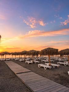 a group of lounge chairs and umbrellas on the beach at Paradox Cantacuzino in Eforie Sud