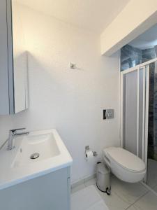 a white bathroom with a sink and a toilet at Suda Pansiyon in Bodrum City +2 photos
