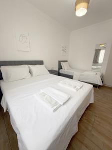 a bedroom with two beds with white sheets at Suda Pansiyon in Bodrum City