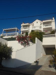 a white building with flowers on the side of it at Peggy's Villa-House with private pool 25' from Athens Intl Airport in Drafí