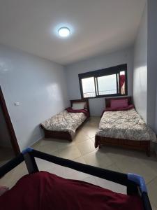 a room with two beds and a window at Harmony immo in Bir el Djir