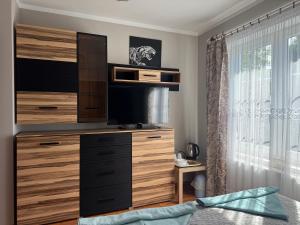 ein Schlafzimmer mit einer großen Kommode, auf der ein Fernseher steht in der Unterkunft Kanarek in Ustka