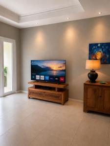 a living room with a flat screen tv on a stand at ARIEL BEACH VILLA* in Grand-Baie