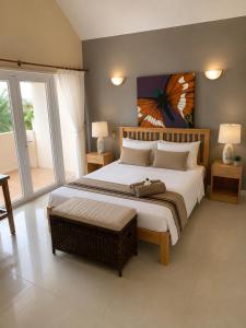 a bedroom with a large bed and a large window at ARIEL BEACH VILLA* in Grand-Baie