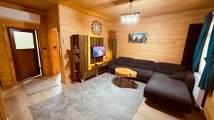 a living room with a couch and a tv at Akyuz Kardesler Hotel & Bungalow in Uzungöl