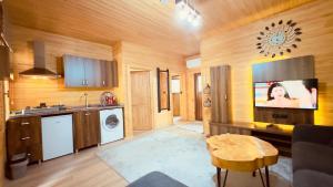 a kitchen with wooden walls and a tv on the wall at Akyuz Kardesler Hotel & Bungalow in Uzungöl