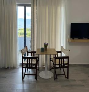 a dining room with a table and chairs and a television at River Residence in Orikum +66 photos