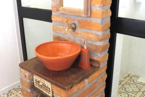 an orange bowl sitting on top of a brick wall at Pousada Pedras Rollantes - Estúdios Enxaimel in Barracão