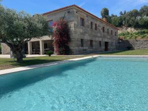 a large swimming pool in front of a building at Quinta Picouto de Cima in Guimarães