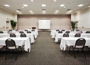 a conference room with white tables and chairs and a whiteboard at Holiday Inn Redding by IHG in Redding